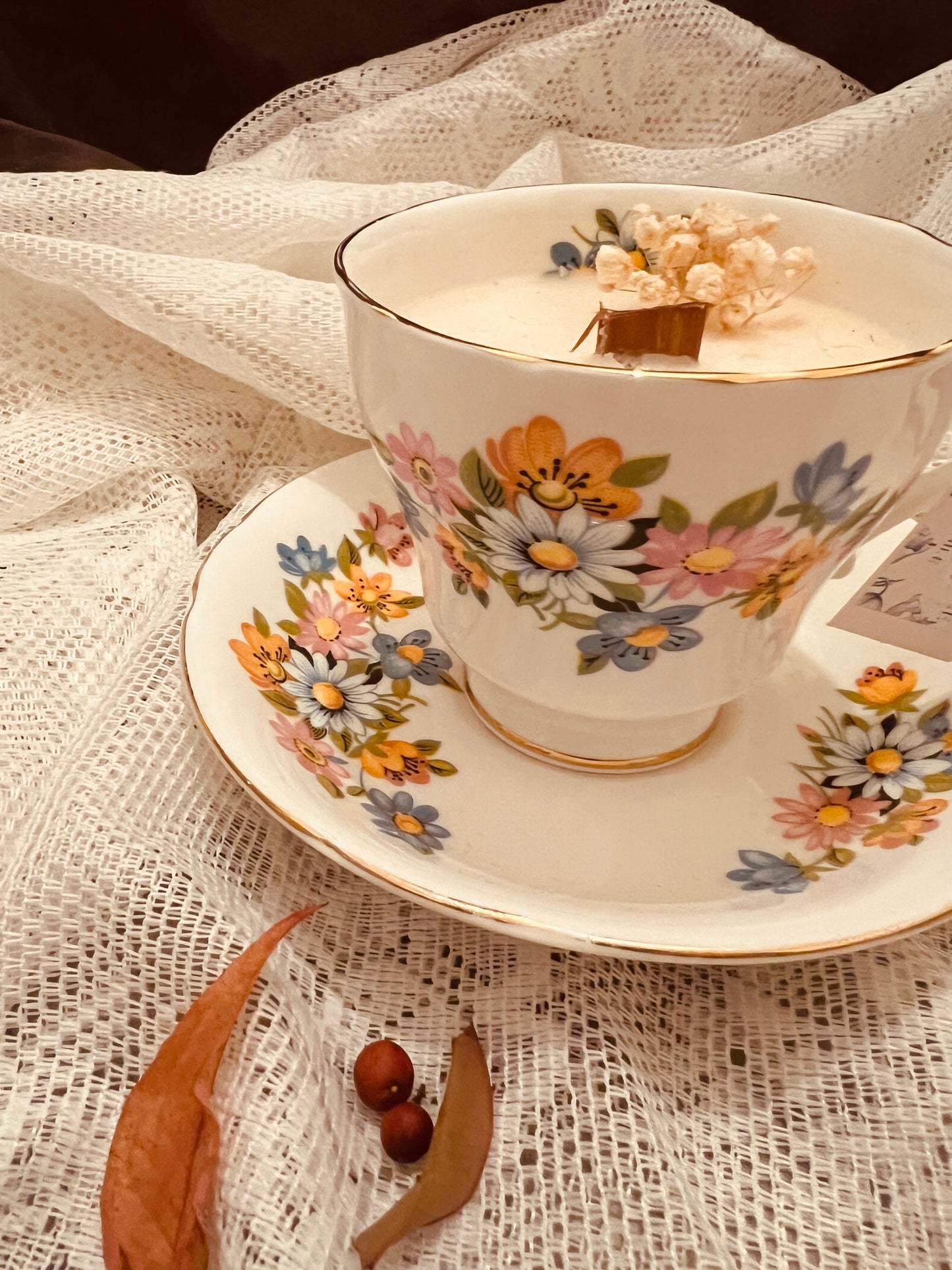 Candela in tazza vintage inglese con margherite colorate